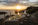 wide-angle documentary photograph of a bride and groom sitting at a luxury decorated wedding table on the cliffside of Park Orsula during a vibrant sunset over Dubrovnik. Photography by Bojan Petričević