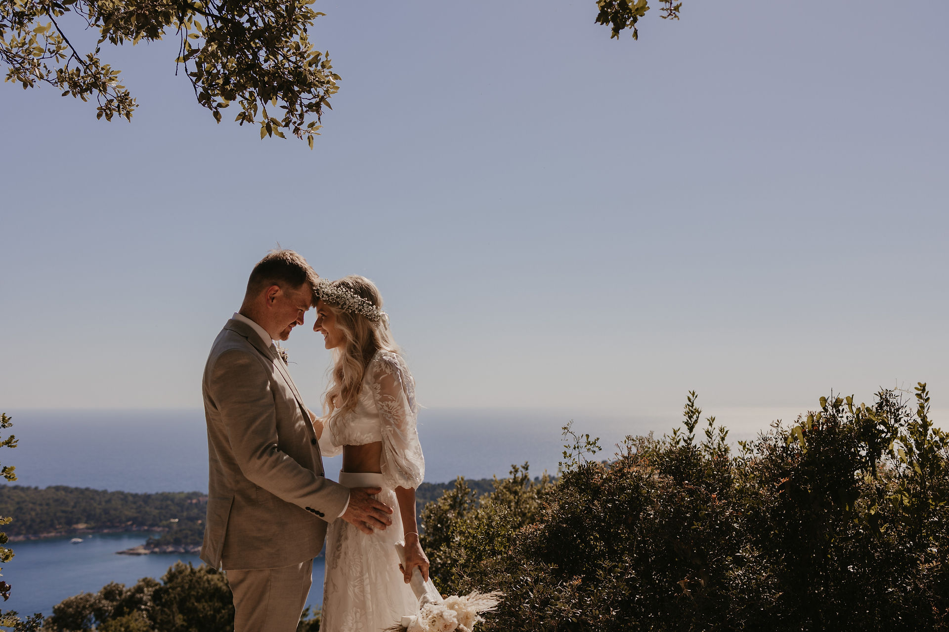 the bride and groom rested their foreheads and hugged each other at the beautiful viewpoint from where you can see the Adriatic Sea and the island near Dubrovnik