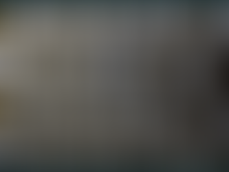 A close-up, eye-level view of rows of aluminium cans stacked on top of each other. One of the cans is open.