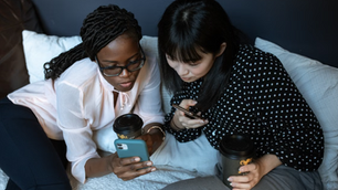 Two girls looking at the NHS app on a phone