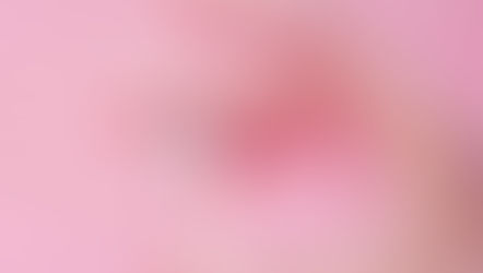 A hand wearing gloves holding a small Covid 19 vaccine bottle