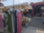 dresses and purses on display at an open air market