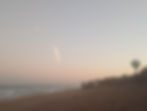 Rocket launches over sunset beach