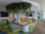 green accents and a tree inside a kids club space