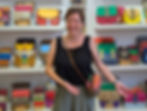 Woman in front of colorful handbags