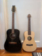 black full sized guitar lined up next to blonde wood smaller guitar