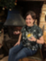 woman holds goblet of gin by a fire