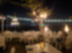 twinkle lit outdoor dining with white tables