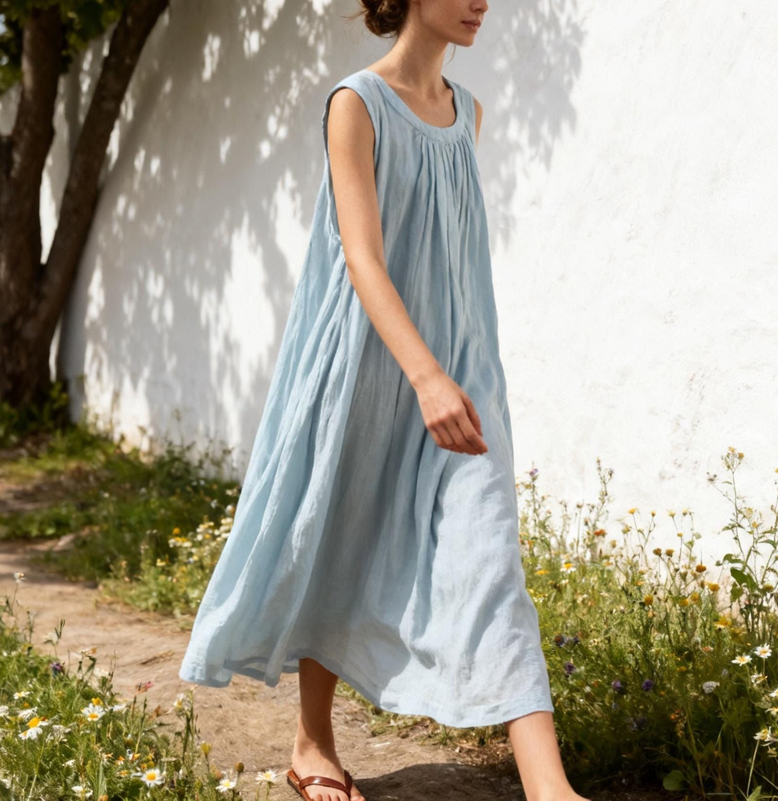 Close-up of romantic neck gathers and organic cotton fabric texture on light blue smock dress