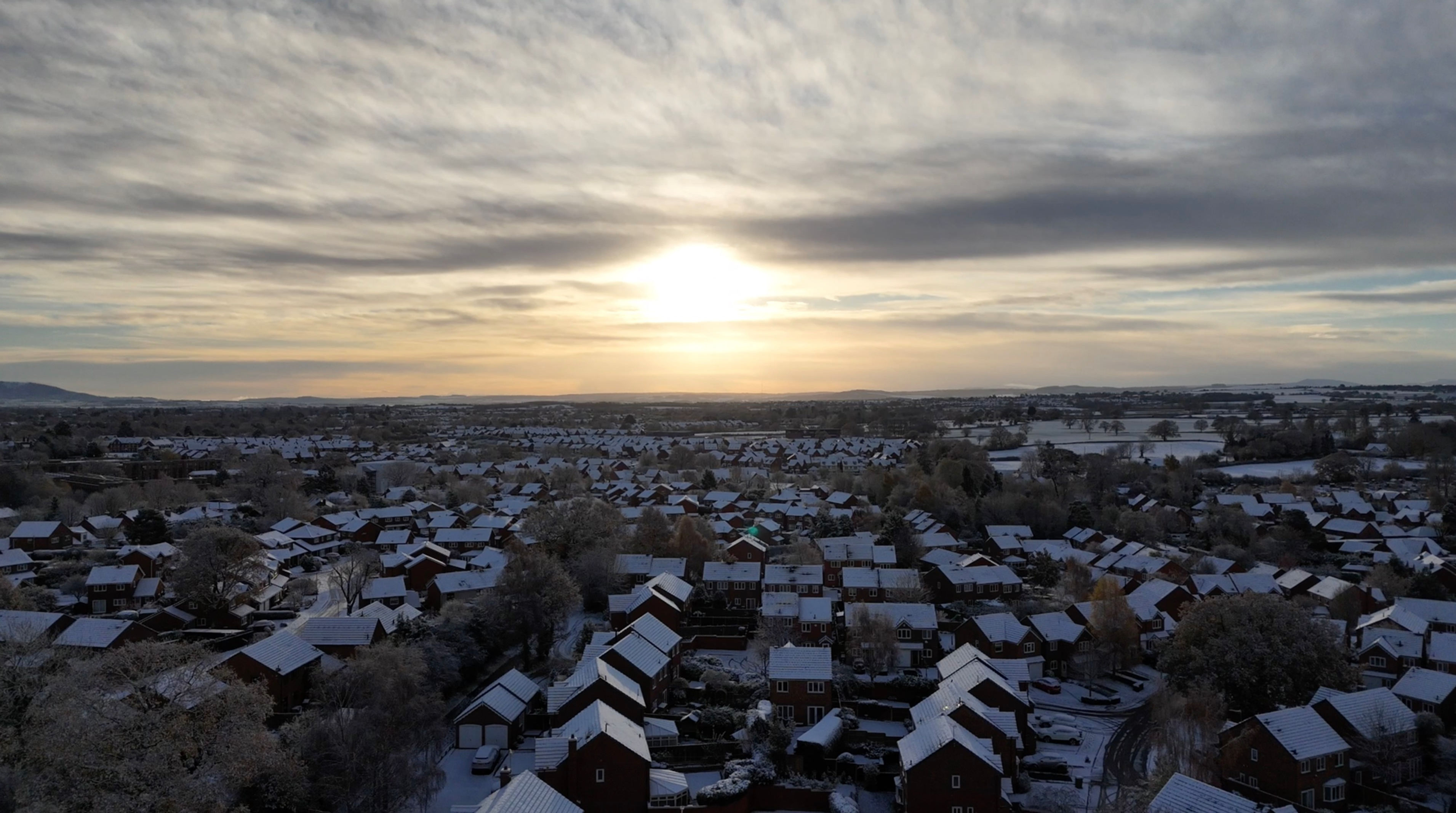 Aerial - English Housing Estate with Snow and Sun setting