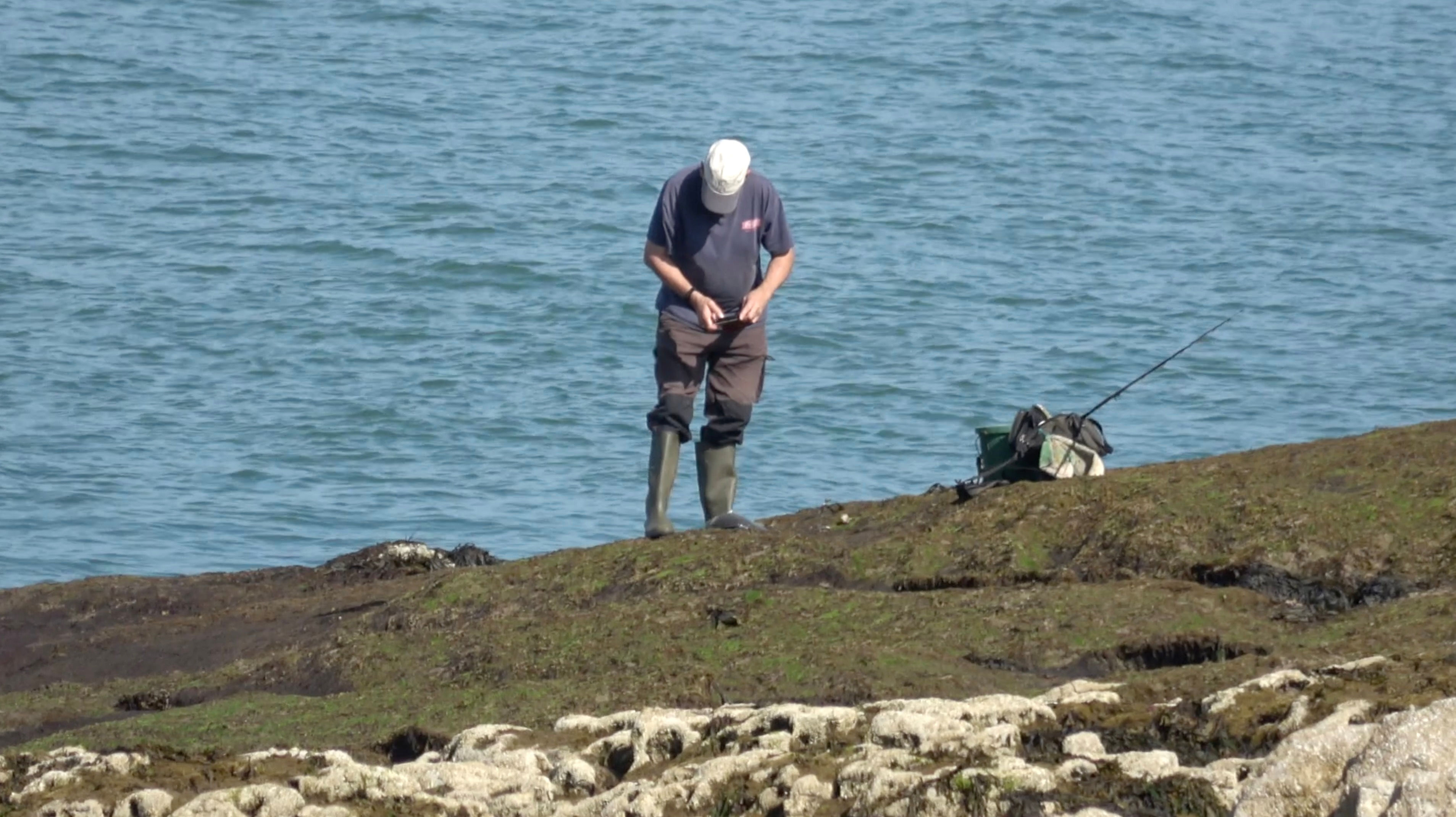 Ocean - Male Angler with Fish on Rocks