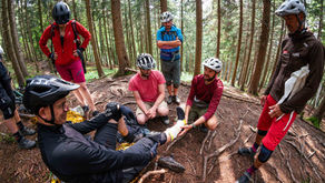 Eine Gruppe Mountainbiker:innen bei einer Erste-Hilfe-Übung