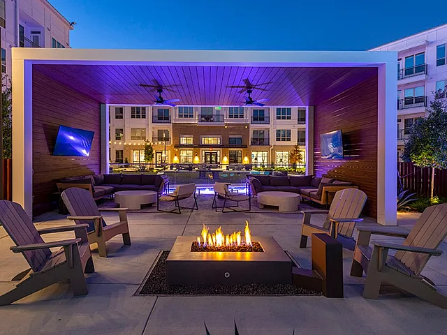 Evening view of apartment courtyard with fire pit and seating