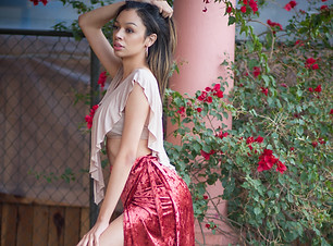 A WOMAN WEARING BAND OF GYPSIES CRUSHED VELEVET SKIRT