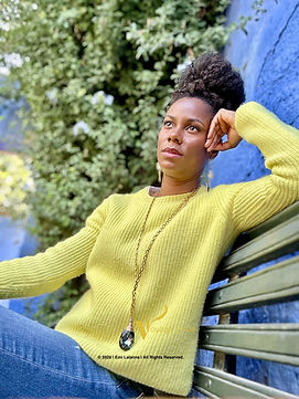 Black woman sits on bench against blue wall in Monastery of Santa Catalina in Arequipa Per