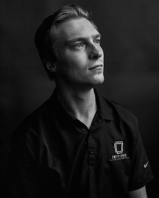 Seth Bench sitting in front of a backdrop in empty space studios' office