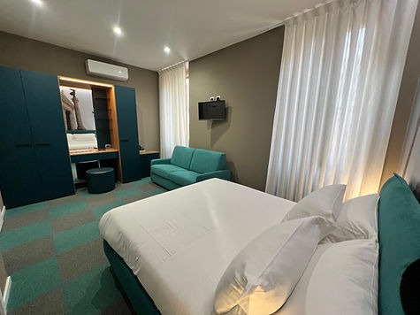 Moderna camera d'albergo con letto matrimoniale, divano, armadio, vicino Vaticano.