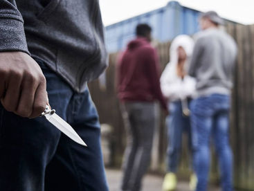 парень держит в руке ножик