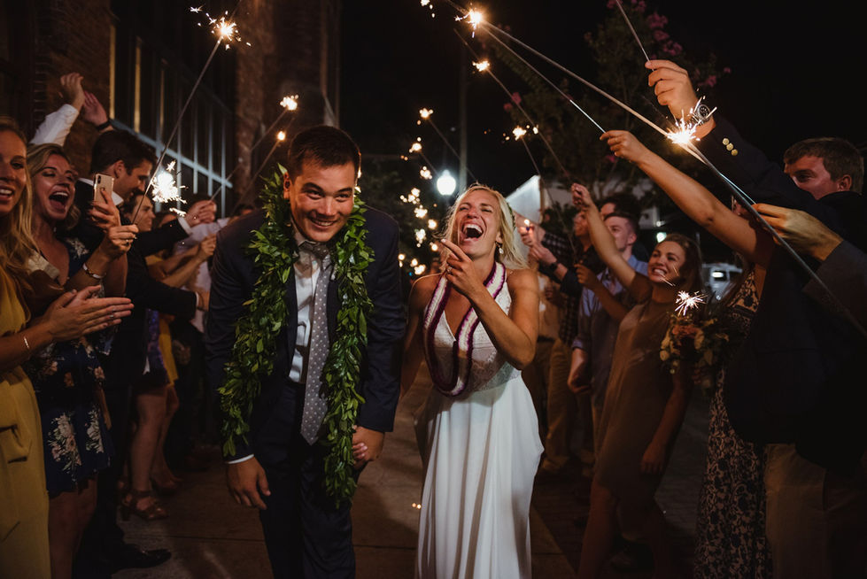 bride and groom making their reception exit through a tunnel of sparklers