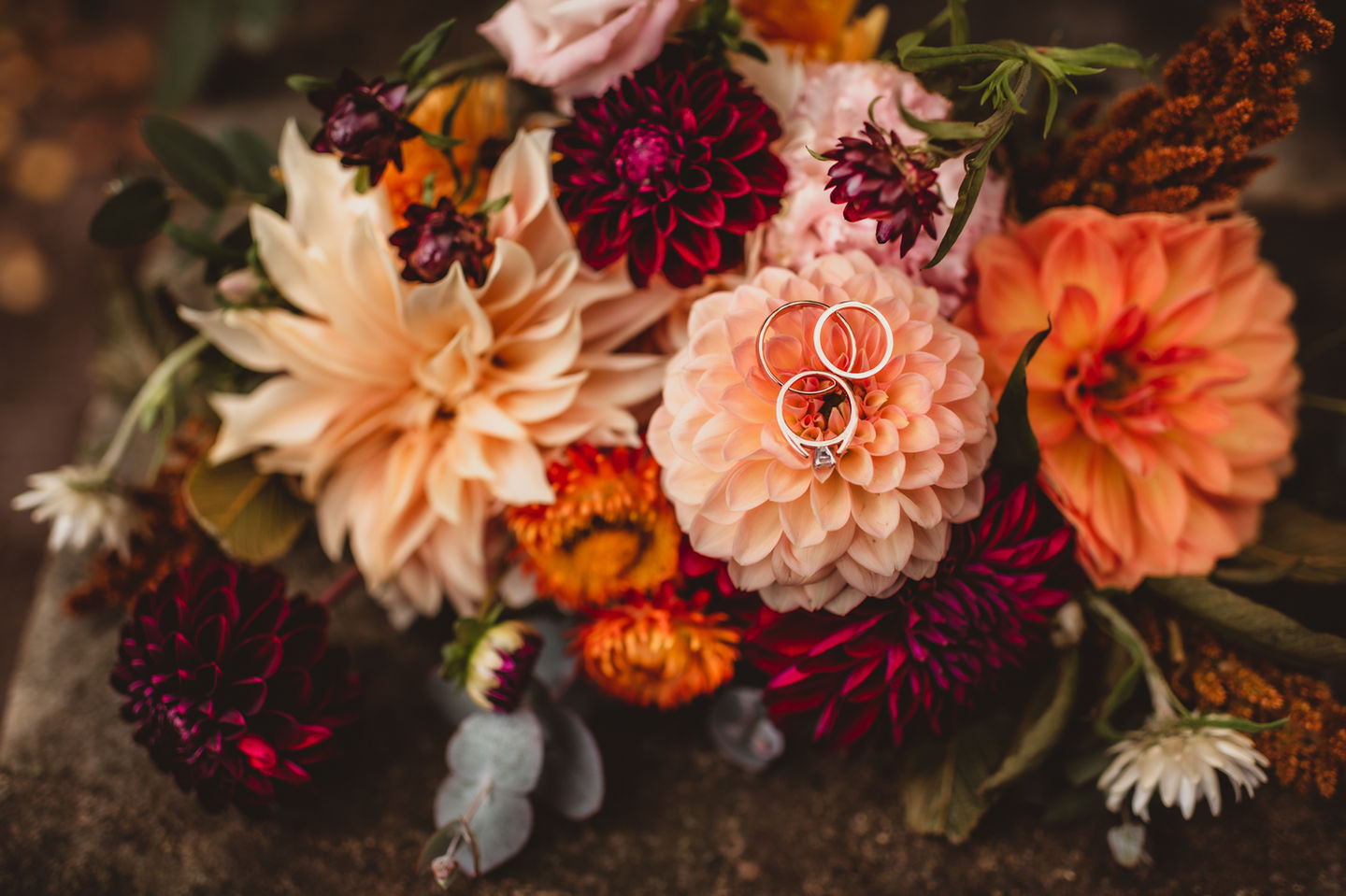 a detail image of a dahlia bouquet holding the wedding rings