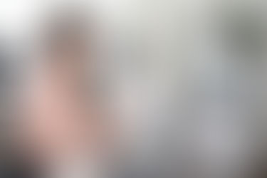 Eine junge Frau in einem Büro vor einem Laptop, welche Akten studiert. Sie lächelt und prüft eventuell ihre Post, welche sie auch digital erhalten hat. Service für KMU's etc.