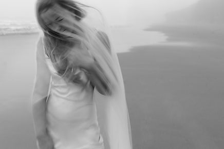 Romantic portrait of a bride on the beach under the veil