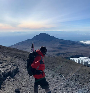 A thumbnail image, featuring a hiker on top of Mount Kilimanjaro, in front of an extraordinary view.