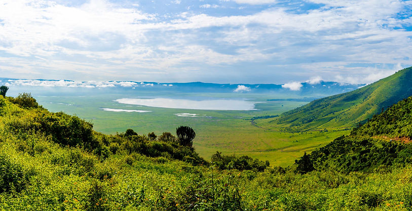 A background picture, featuring a view from the rim of the Ngorongoro Crater, overlooking the lush green landscape of the crater, and Lake Magadi below.