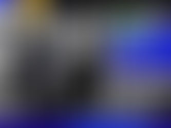 Foto mostra duas pessoas sentadas em frente a uma exposição com projeções de diversas imagens na parede de uma sala escura. Sobrepostos, há os textos "Nova turma! Inteligência Artificial e Cultura" e "Inscrições abertas".