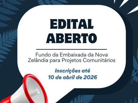 Banner com fundo azul escuro e detalhes de folhas em azul um pouco mais claro. Sobreposto, um balão de diálogo e um megafone, com os textos "Edital aberto", "Fundo da Embaixada da Nova Zelândia para Projetos Comunitários" e "Inscrições até 10 de abril de 2026".
