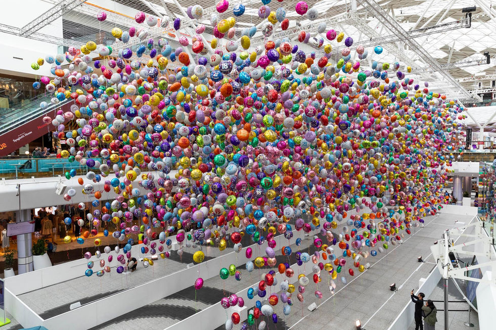 Hundreds of colourful birthdays balloons suspended in the atrium of Westfield London for CALM's Missed Birthdays campaign, photographed by London PR photographer Harvey Aspell