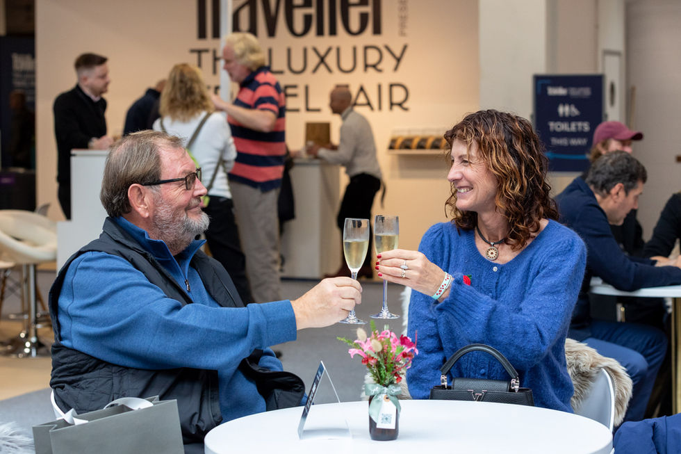 Two visitors clink champagne glasses and smile at one another at The Luxury Travel Fair at Olympia, London, November 2025, captured by London event photographer Harvey Aspell