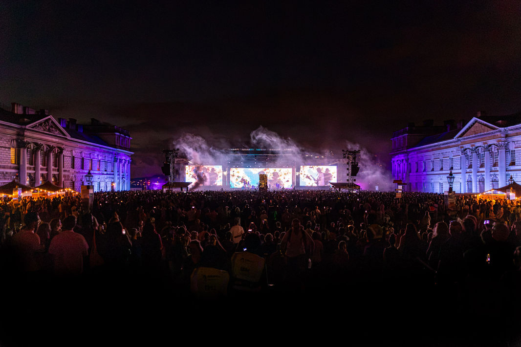 The grounds of the Old Royal Naval College in Greenwich packed with fans watching a live Moby performance, photographed by London live music photographer Harvey Aspell