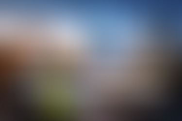 Ingenieure analysieren Baupläne auf einer digitalen Baustelle mit Hochhäusern, Krananlagen und visualisierten Datenmodellen zur präzisen Baukostenprognose