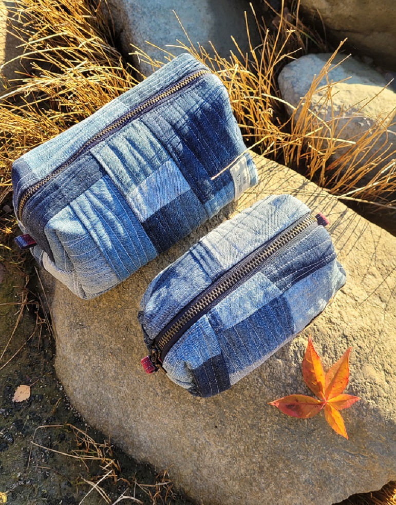 Overhead view of two handmade quilted patchwork denim pouches.