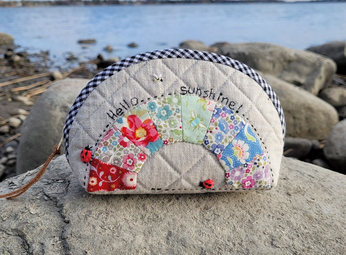 Colorful patchwork pouch with spring motifs like bees and flowers
