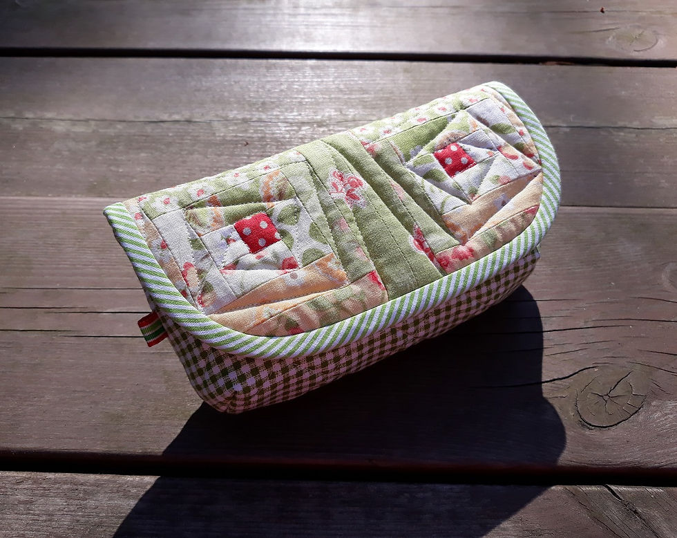 Thumbnail: Top view of tiny log cabin blocks on sunglasses case flap, showcasing quilting.