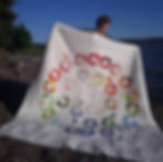 Full view of the quilt held by the maker, showcasing its bold, modern design.