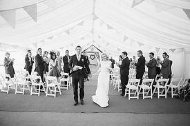 Niki and Stu coming down the aisle, just married, black and white