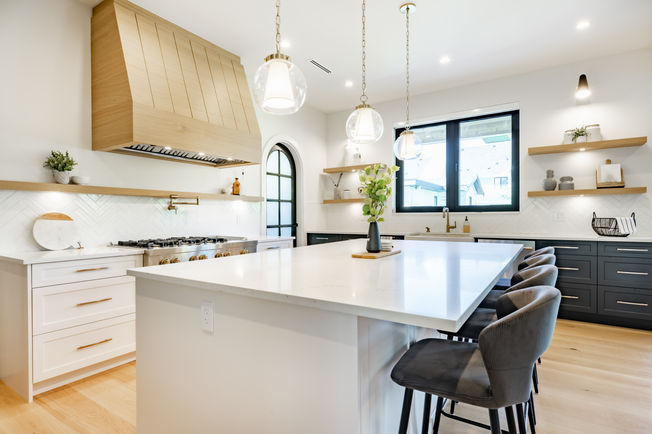Transitional kitchen with wood hood and white countertops and cabinets