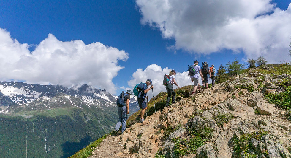 hikers climbing a ridge on the tour du mont blanc in france