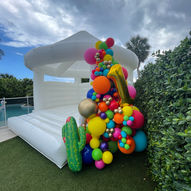 first fiesta colorful balloon garland on a white bounce house