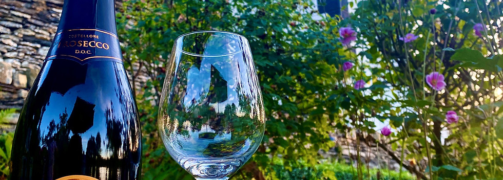 Bottle of prosecco with a glass in front of Bron Y Graig