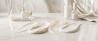 Treatment lotions and skincare products spread across a smooth surface in warm natural light