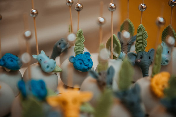 A detail photo of intricate cake pops decorated to look like jungle animals