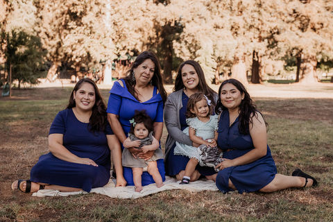 Three generations of women in a family sitting together in a park