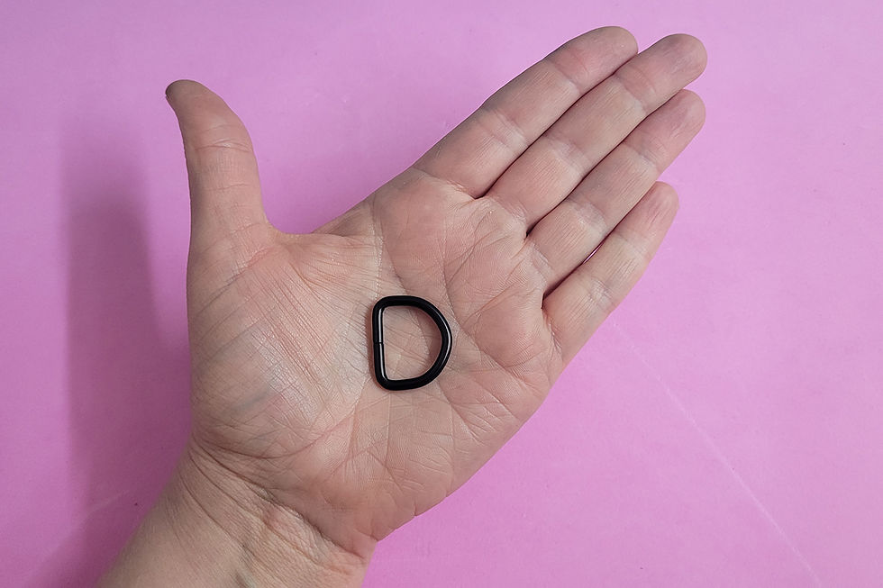 Miniaturbild: Kleiner schwarzer D-Ring in einer Handfläche. Er passt ungefähr in die Kuhle zwischen Herz- und Kopflinie der Hand.