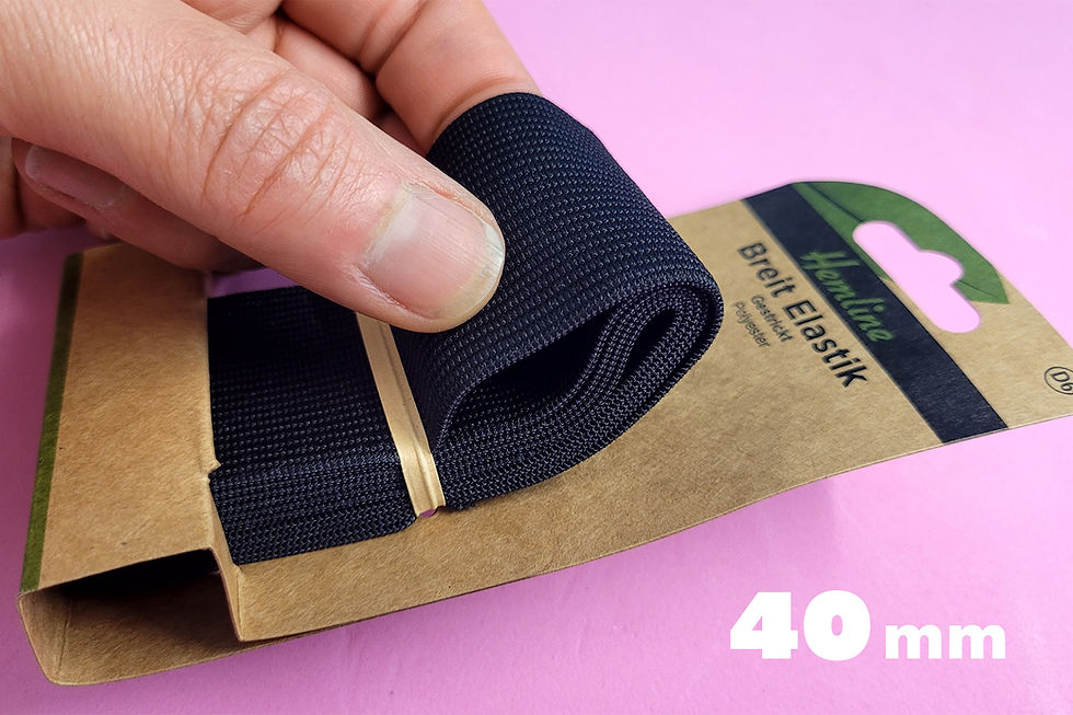 eine Hand hält ein sehr breites Gummiband zwischen den Fingern. Text: 40mm