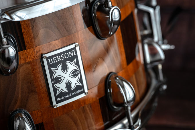 Close up of badge view of chequerboard style design snare drum handcrafted by Bersoni Custom Drums.