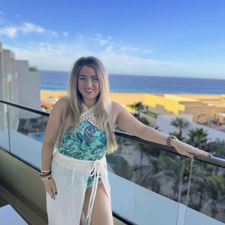 Ashton, a travel agent, soaking in the views from a balcony in Cabo, Mexico, during a resort familiarization trip to offer firsthand travel advice.